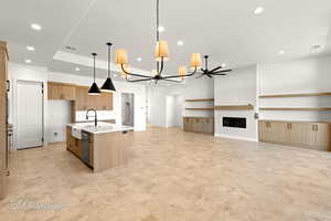 Kitchen featuring dishwashing machine, recessed lighting, visible vents, light countertops, and a center island with sink