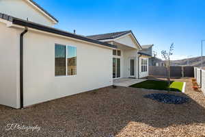 Rear view of house featuring a patio area, a fenced backyard, and stucco siding