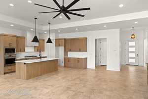 Kitchen with recessed lighting, stainless steel appliances, premium range hood, light countertops, and brown cabinets