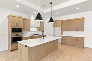 Kitchen featuring appliances with stainless steel finishes, light countertops, a sink, and recessed lighting