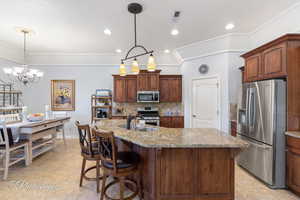 Kitchen with stainless steel appliances, a sink, backsplash, and light stone counters