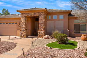 Prairie-style house featuring a garage, a tiled roof, stone siding, and stucco siding