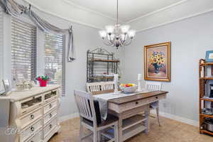 Dining area with a notable chandelier, baseboards, and light tile patterned floors