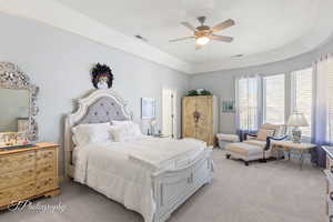 Bedroom with light carpet, ceiling fan, and visible vents