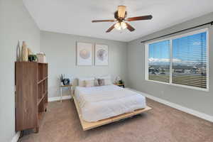 Bedroom with ceiling fan, carpet, and baseboards