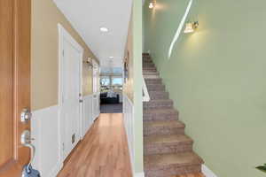 Staircase featuring a wainscoted wall, wood finished floors, and recessed lighting