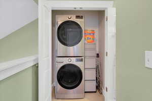 Washroom with laundry area, light tile patterned flooring, and stacked washer / drying machine