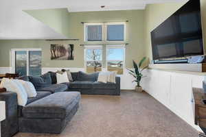 Carpeted living room featuring a wainscoted wall