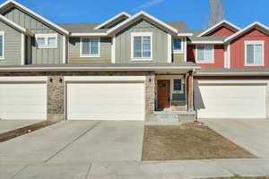 View of property with an attached garage, board and batten siding, and concrete driveway