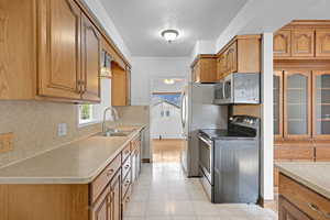 Kitchen featuring stainless steel appliances, a sink, and brown cabinets