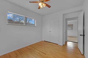 Unfurnished bedroom featuring light wood-type flooring, a closet, ceiling fan, and baseboards