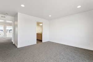 Empty room featuring baseboards, carpet floors, visible vents, and recessed lighting