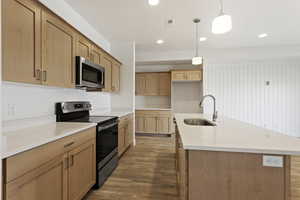 Kitchen with visible vents, wood finished floors, light countertops, stainless steel appliances, and a sink