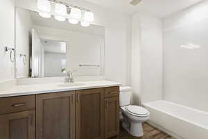 Full bathroom with visible vents, wood finished floors, vanity, and toilet