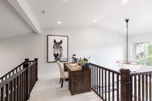 Hall with recessed lighting, visible vents, light carpet, vaulted ceiling, and an upstairs landing