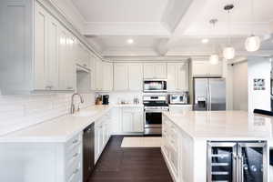 Kitchen featuring tasteful backsplash, beverage cooler, dark wood finished floors, appliances with stainless steel finishes, and a sink