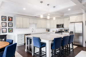 Kitchen featuring appliances with stainless steel finishes, dark wood-type flooring, a kitchen bar, and light stone countertops