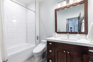 Bathroom with vanity, toilet, and shower / tub combo with curtain
