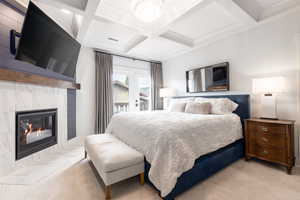 Bedroom with visible vents, coffered ceiling, a tile fireplace, beamed ceiling, and access to outside