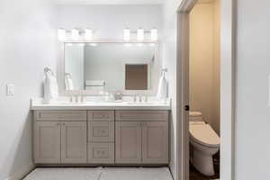 Full bath with a sink, toilet, and double vanity