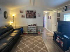 Living area with lofted ceiling with beams and wood finished floors