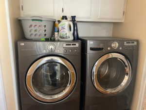 Washroom featuring cabinet space and washer and dryer