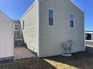 View of side of property featuring central AC and a yard