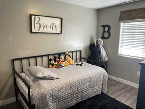 Bedroom featuring baseboards and wood finished floors