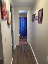 Hall with baseboards and wood finished floors