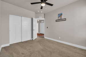 Unfurnished bedroom with carpet floors, visible vents, baseboards, and a closet