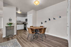 Dining room with a toaster, baseboards, and wood finished floors