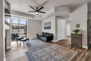 Living area with visible vents, dark wood finished floors, and baseboards