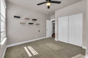 Unfurnished bedroom with a closet, carpet, visible vents, and baseboards