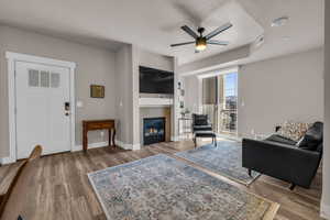 Living room featuring a textured ceiling, a tiled fireplace, and wood finished floors