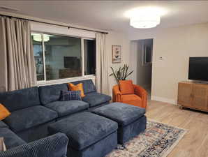 Living area with baseboards, visible vents, and light wood finished floors