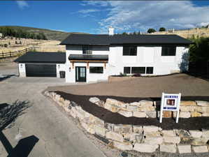 Modern inspired farmhouse with concrete driveway, metal roof, an attached garage, a standing seam roof, and fence