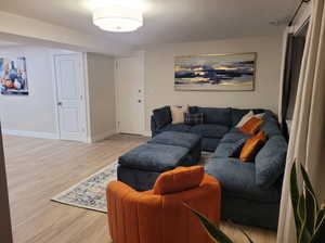 Living room featuring baseboards, visible vents, and light wood-style floors