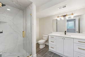 Bathroom with vanity, toilet, and an enclosed shower