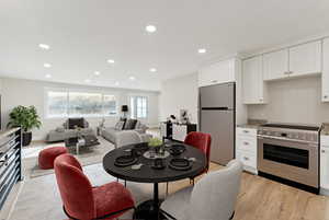 Dining space with baseboards, light wood-style floors, and recessed lighting