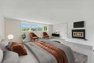 Carpeted bedroom featuring a fireplace and baseboards