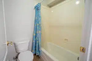 Full bath featuring shower / tub combo, toilet, and tile patterned floors