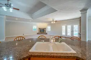 Kitchen featuring a textured ceiling, ornamental molding, open floor plan, and a sink