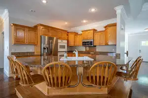 Kitchen featuring dark wood-style flooring, a sink, ornamental molding, appliances with stainless steel finishes, and brown cabinets