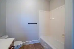 Bathroom featuring vanity, toilet, and baseboards