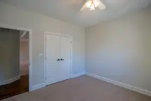 Unfurnished bedroom featuring carpet floors, a closet, ceiling fan, and baseboards