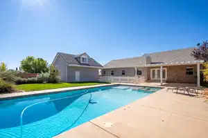 View of pool featuring a patio, fence, a pool with connected hot tub, french doors, and a lawn