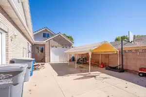 View of patio with a garage, concrete driveway, and fence