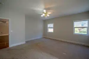 Unfurnished room with a ceiling fan, baseboards, and carpet flooring