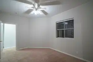 Carpeted spare room with a ceiling fan, a textured ceiling, and baseboards