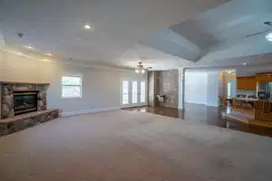 Living area with visible vents, ceiling fan, ornamental molding, a textured ceiling, and a fireplace